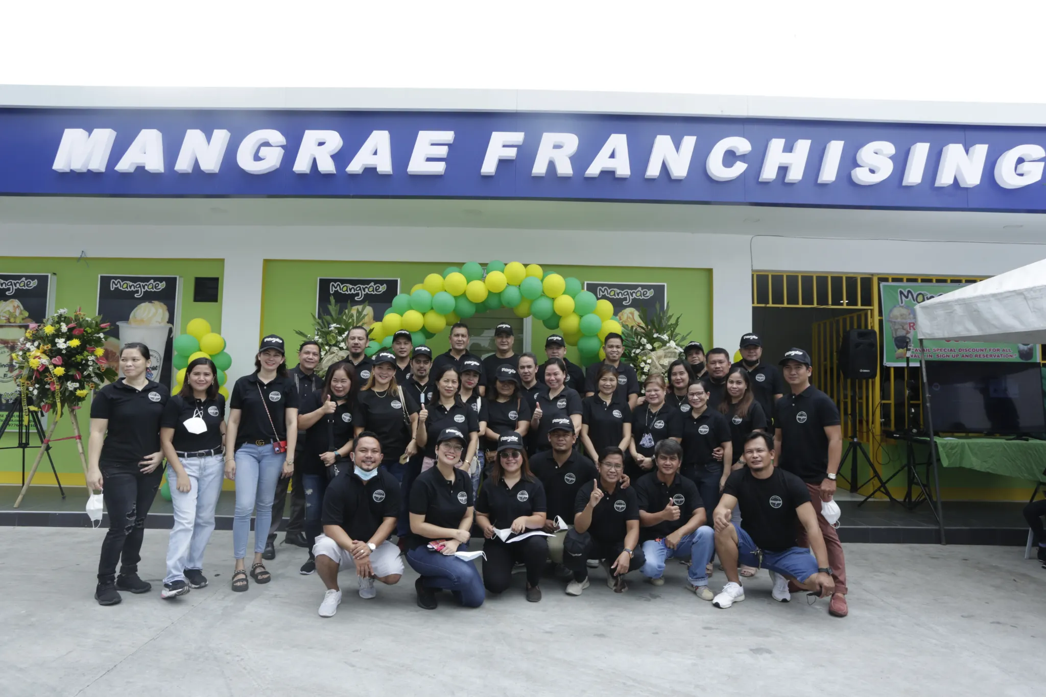Mangrae team gathered in front of a branch during a celebration