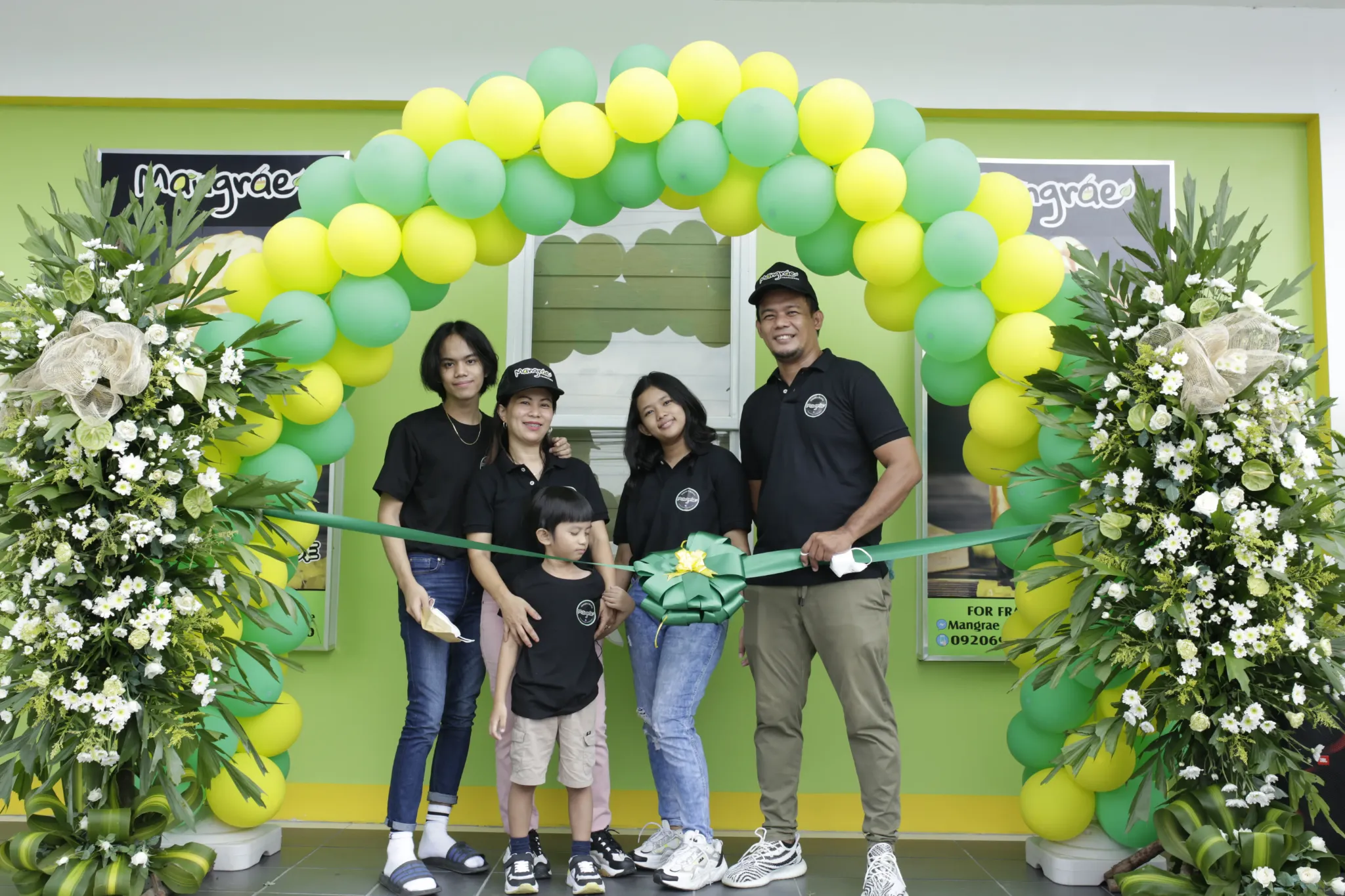Mangrae family and team at a ribbon-cutting celebration